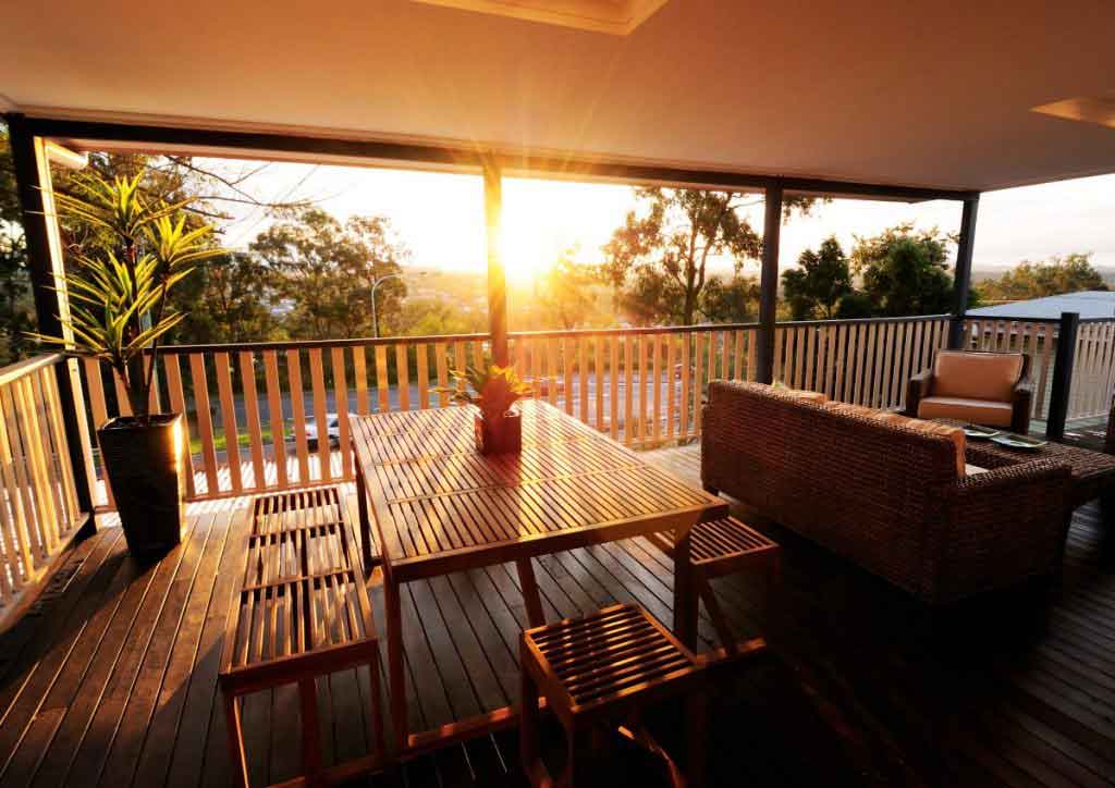A deck with a table and chairs overlooking the sunset, perfect for a relaxing home renovation project.