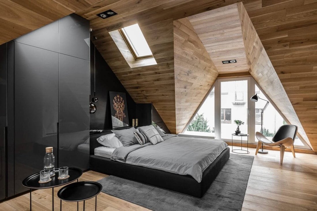 A cozy attic bedroom featuring wooden walls and a comfortable bed. Perfect for a home remodeling project to enhance your living space.