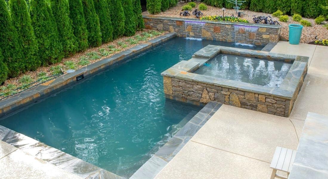 A small backyard pool with a hot tub ideal for home renovations.