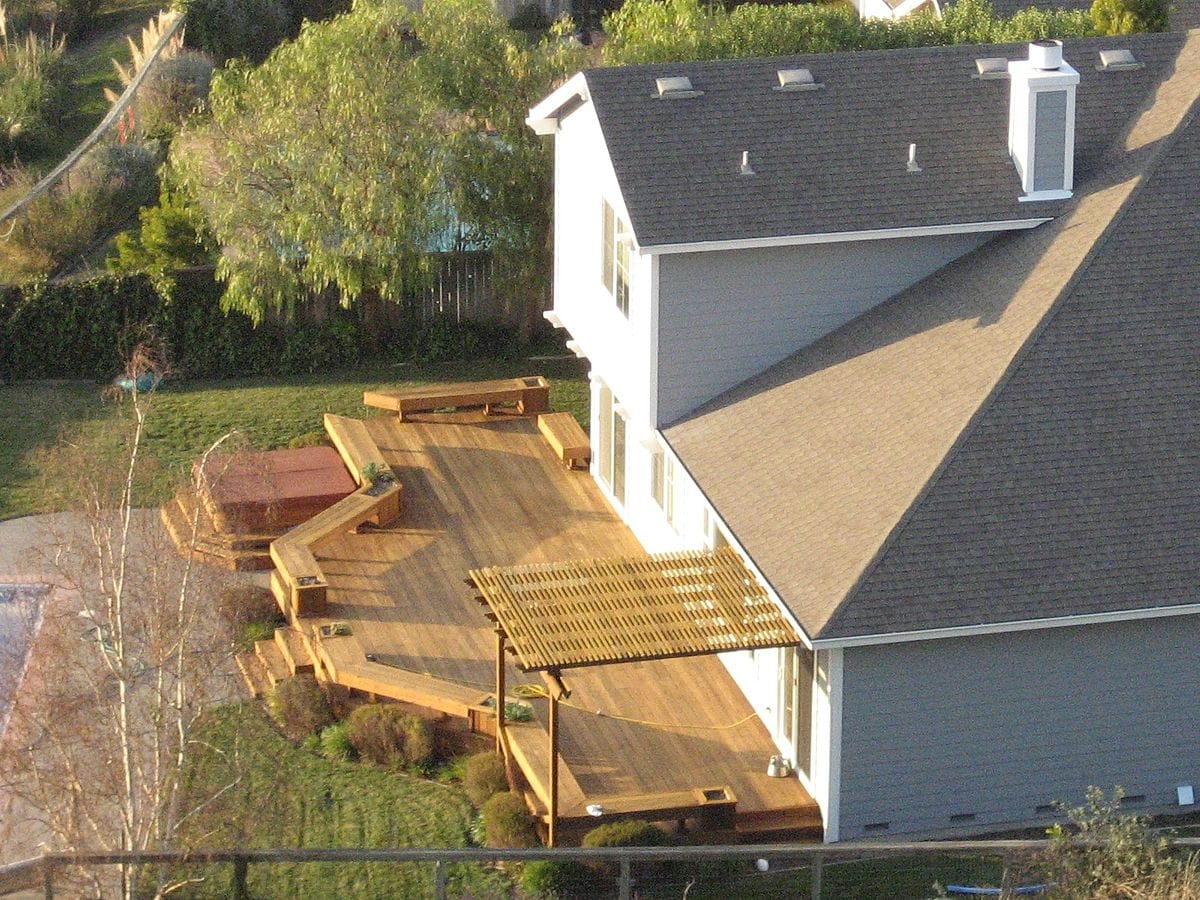 A home remodeling project that involves adding a deck to a house is captured in an aerial view.