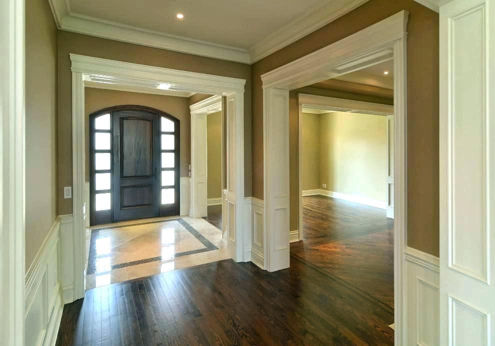 A home renovation project featuring a hallway with newly installed hardwood floors and a door.