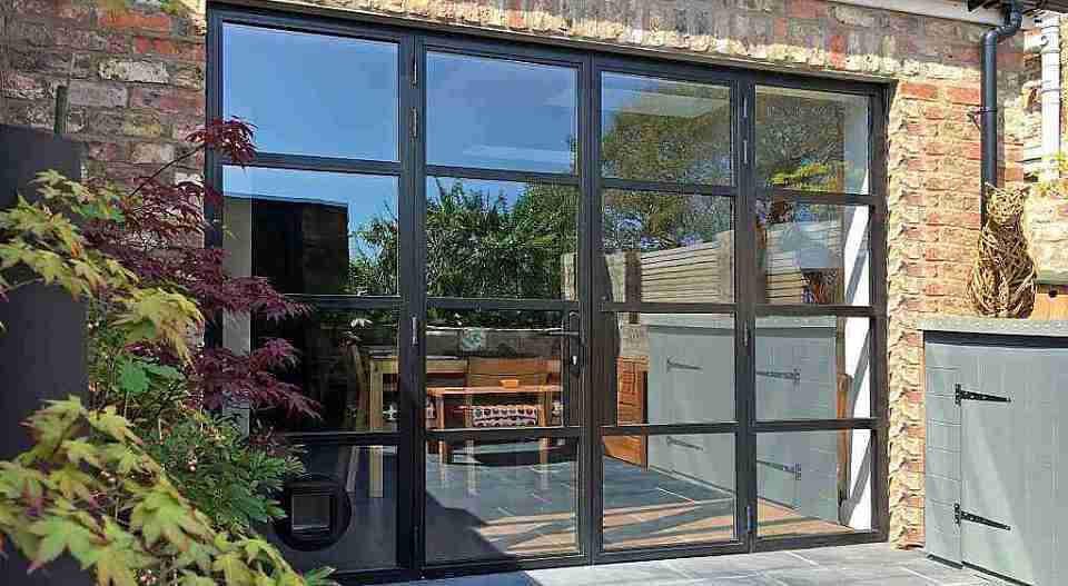 A home renovation project featuring a garage door with a black frame and glass windows.