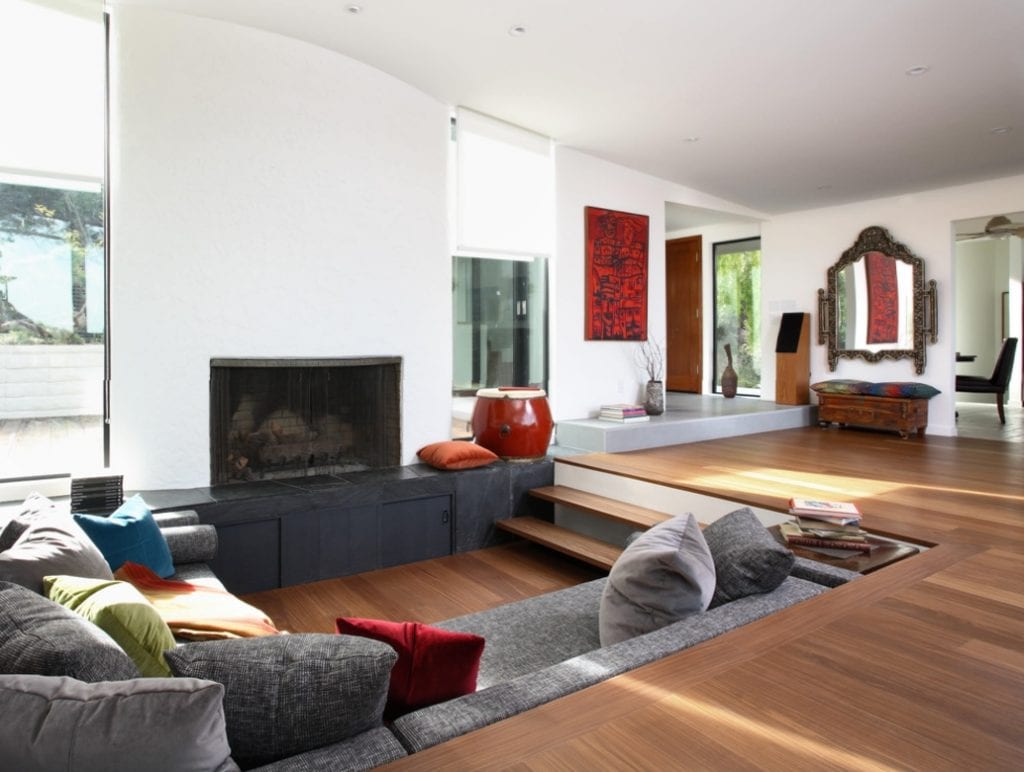 A modern living room with wooden floors and a fireplace, perfect for home renovation projects.