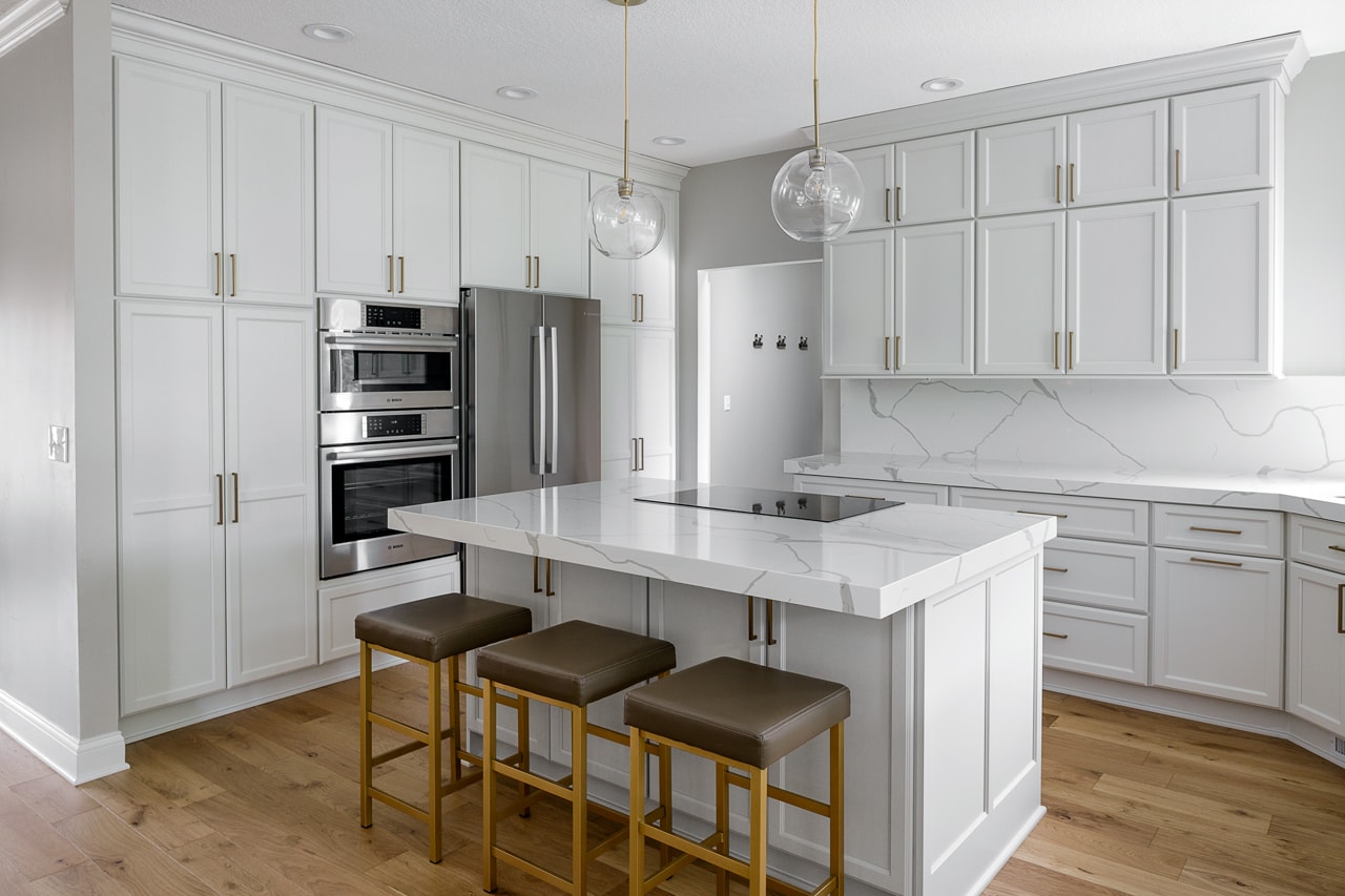 kitchen remodeled with white cabinets and countertops