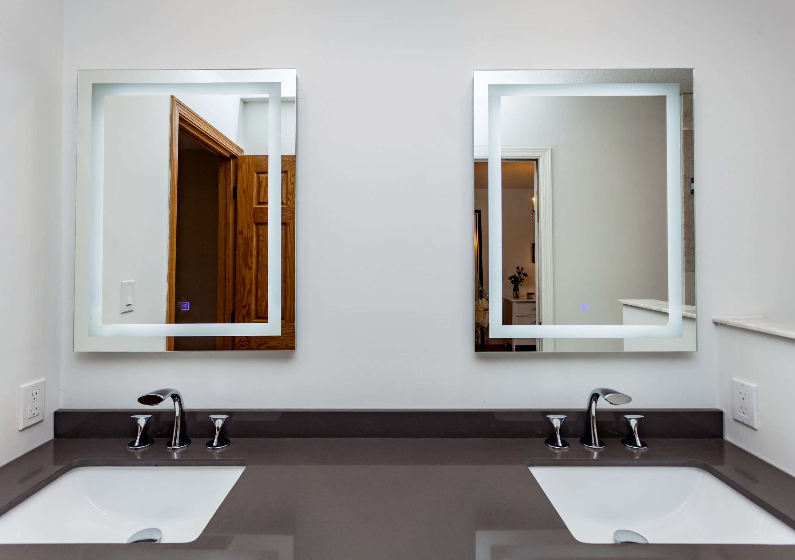 double vanity with mirrors and dark countertop
