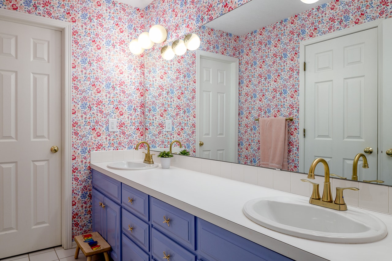 kids bathroom with flower wall paper and purple vanity