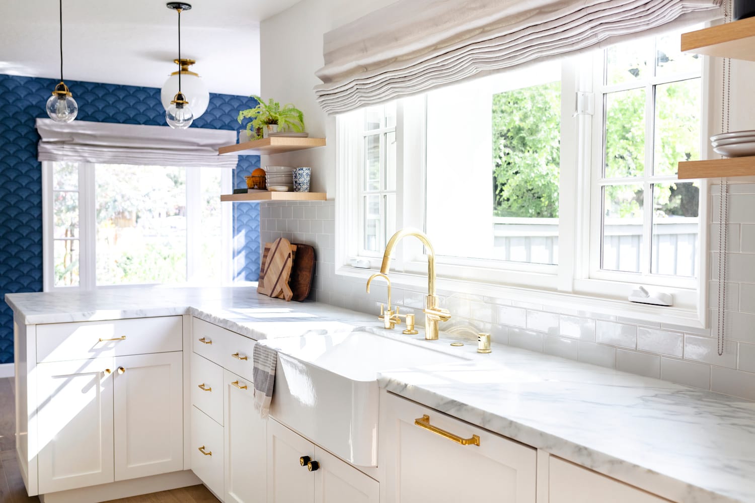 A white kitchen with blue walls and a gold sink in Ankeny.