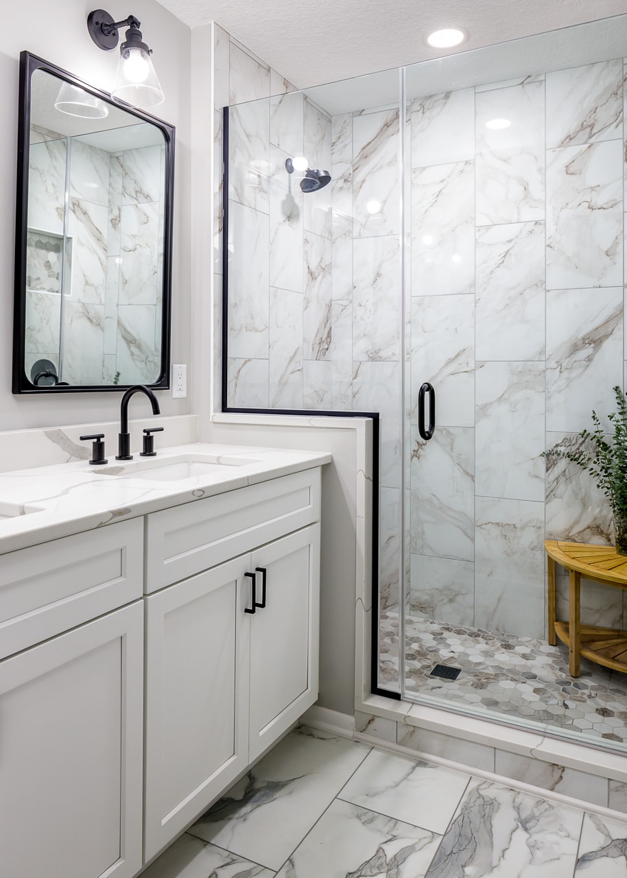         A bathroom renovation featuring marble floors and a walk in shower.