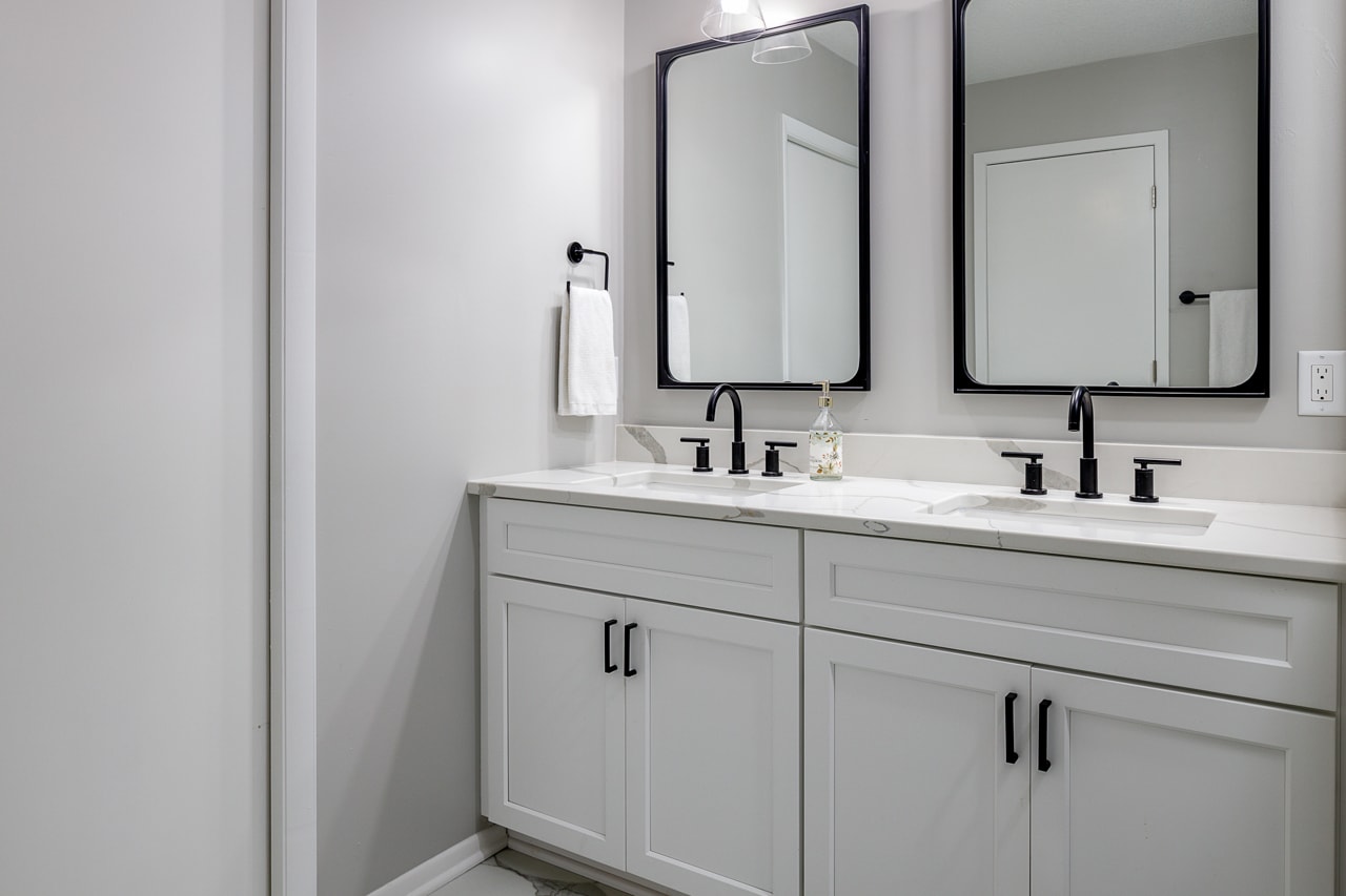 A renovated bathroom with two sinks and mirrors.