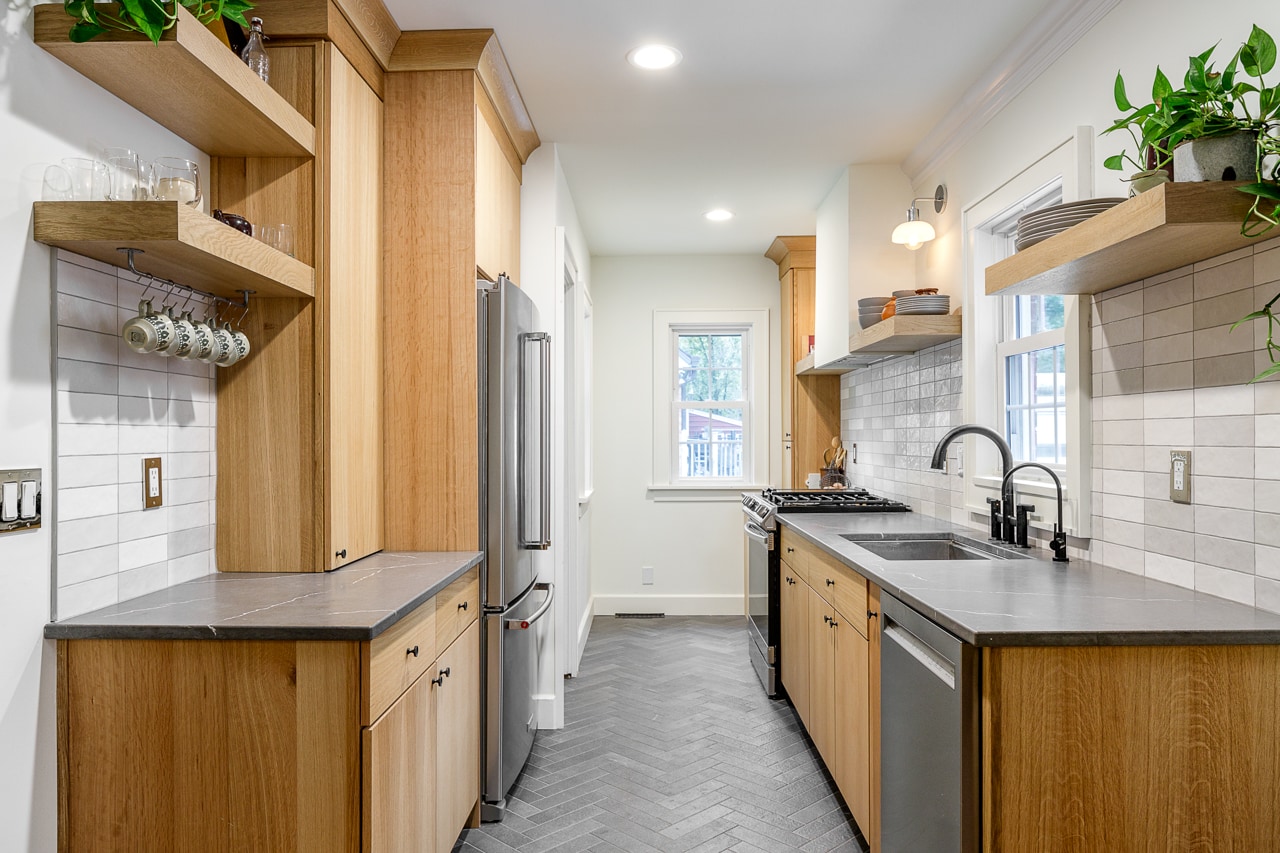 A kitchen with wood cabinets and stainless steel appliances undergoes Kitchen Remodeling.
