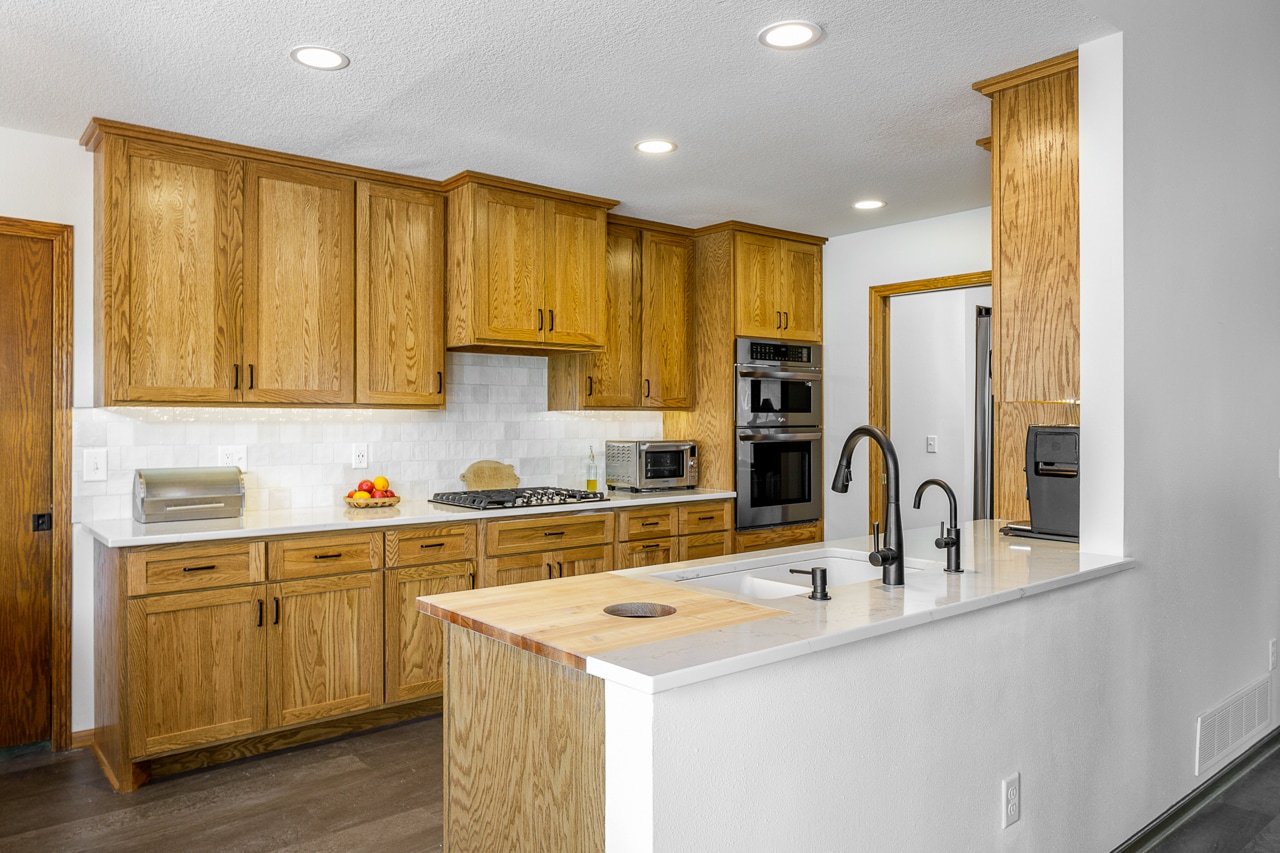 A renovated kitchen with wood cabinets and stainless steel appliances.