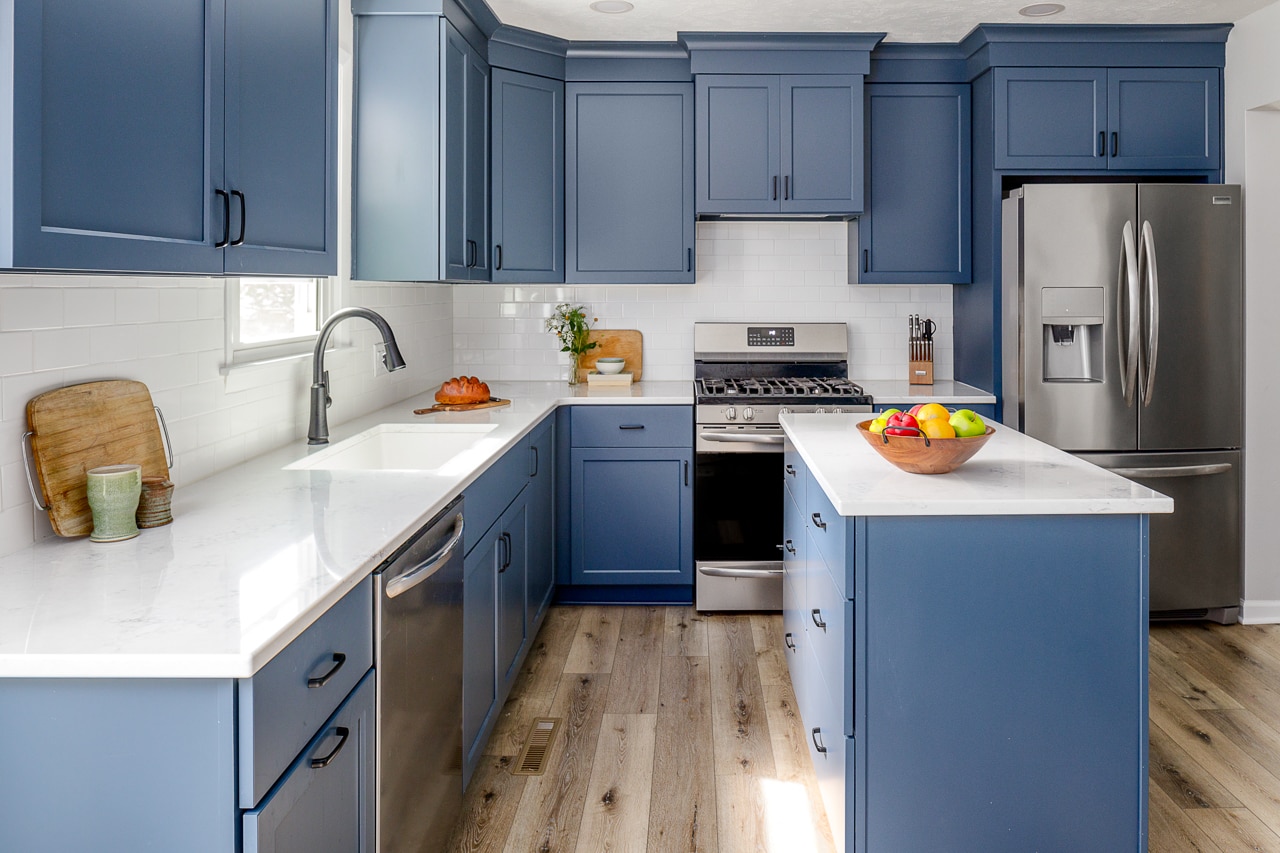 A kitchen renovation with blue cabinets and hardwood floors.